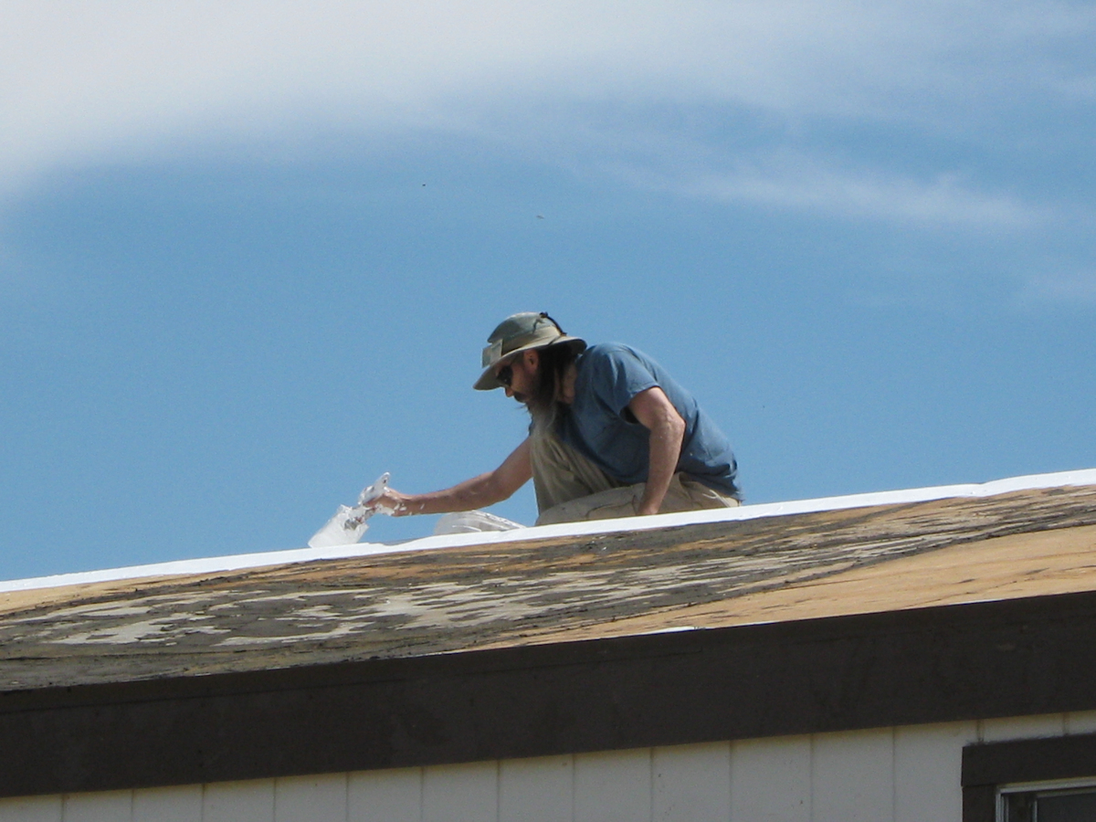 Embedding poly-mesh in first coat of elastomeric coating on mobile home roof
